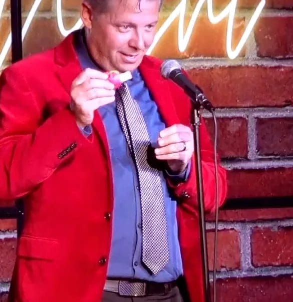 A man in red jacket holding onto a microphone.