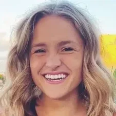 A woman with long blonde hair smiling for the camera.